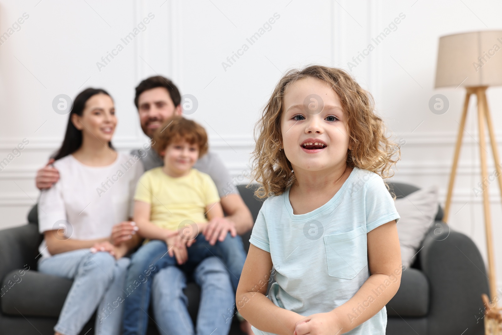 Photo of Happy family having fun at home. Daughter dancing while her relatives resting on sofa