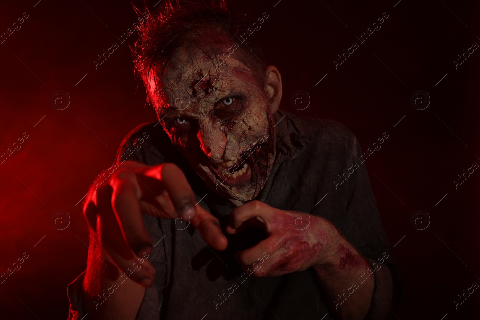 Photo of Scary zombie on dark background. Halloween monster