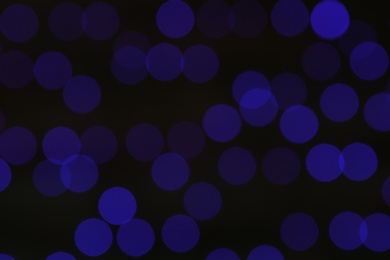 Photo of Blurred view of blue Christmas lights on dark background