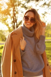 Photo of Beautiful young woman wearing stylish clothes in autumn park