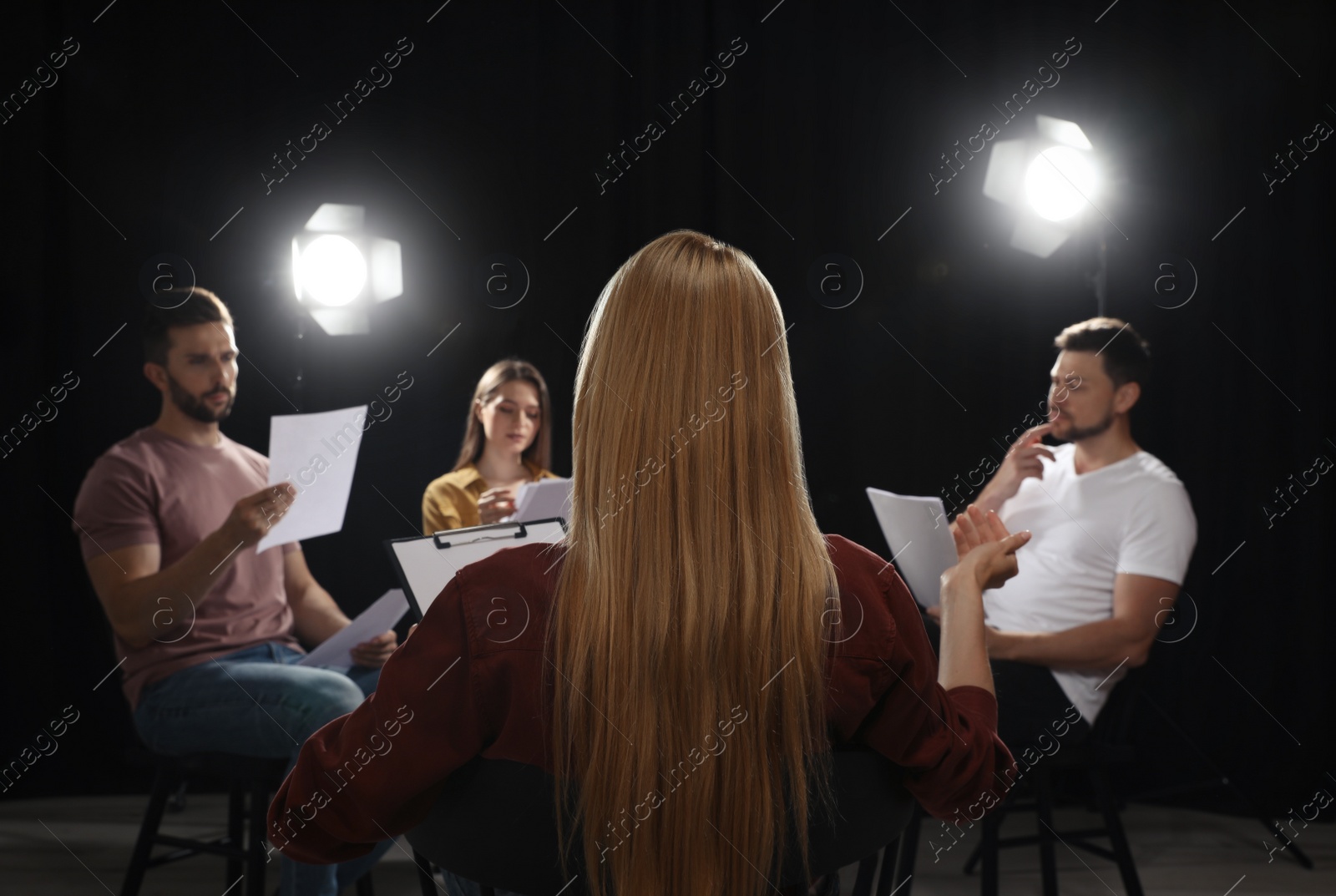 Photo of Professional actors reading their scripts during rehearsal in theatre