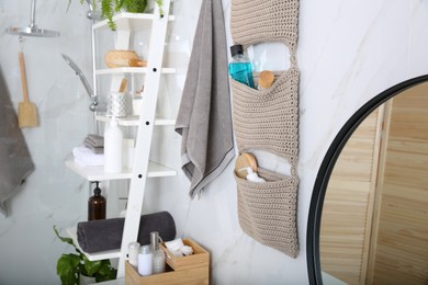 Knitted organizer hanging on wall in bathroom