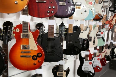 Photo of Rows of different guitars in music store