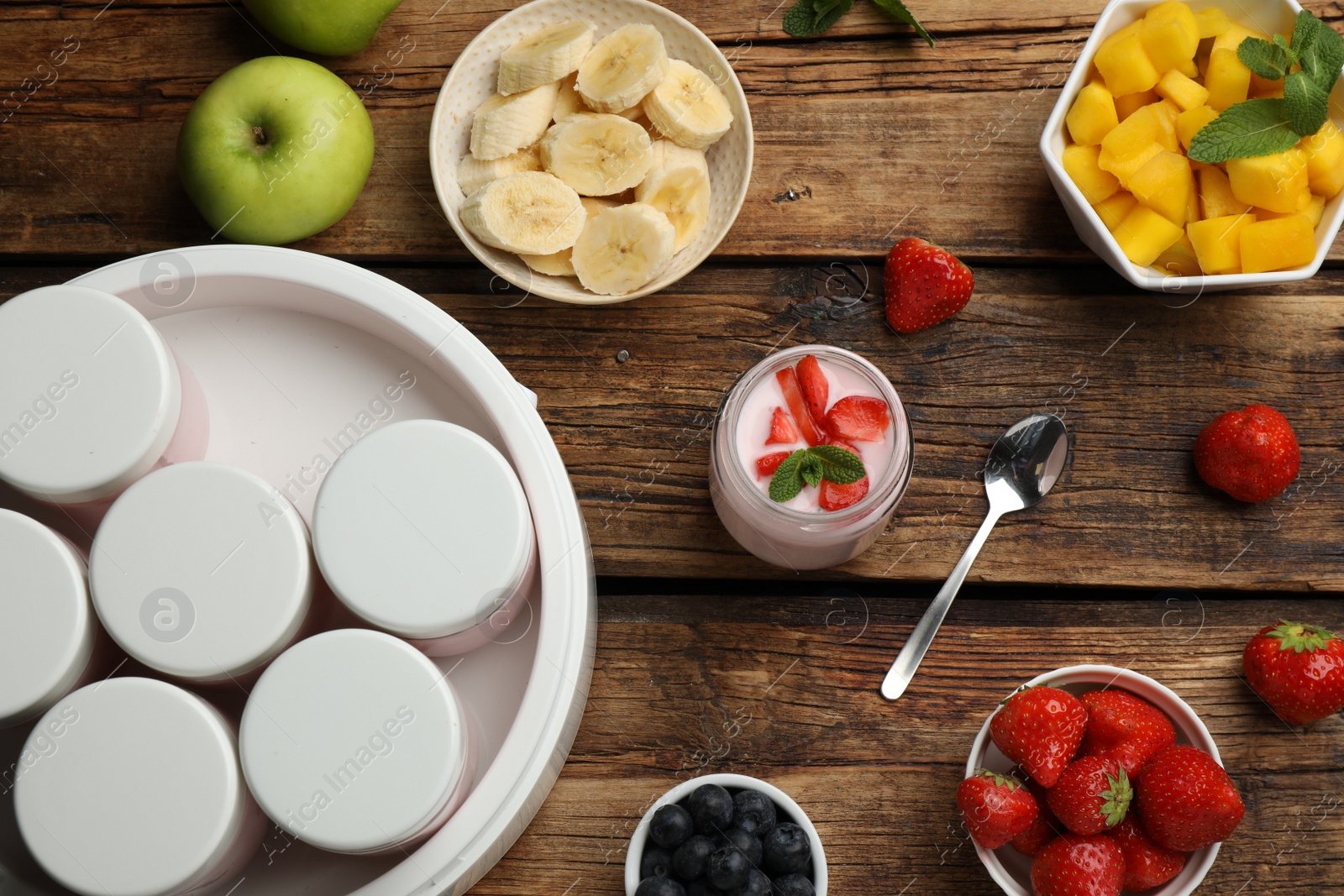 Photo of Modern yogurt maker with full jars and different fruits on wooden table, flat lay