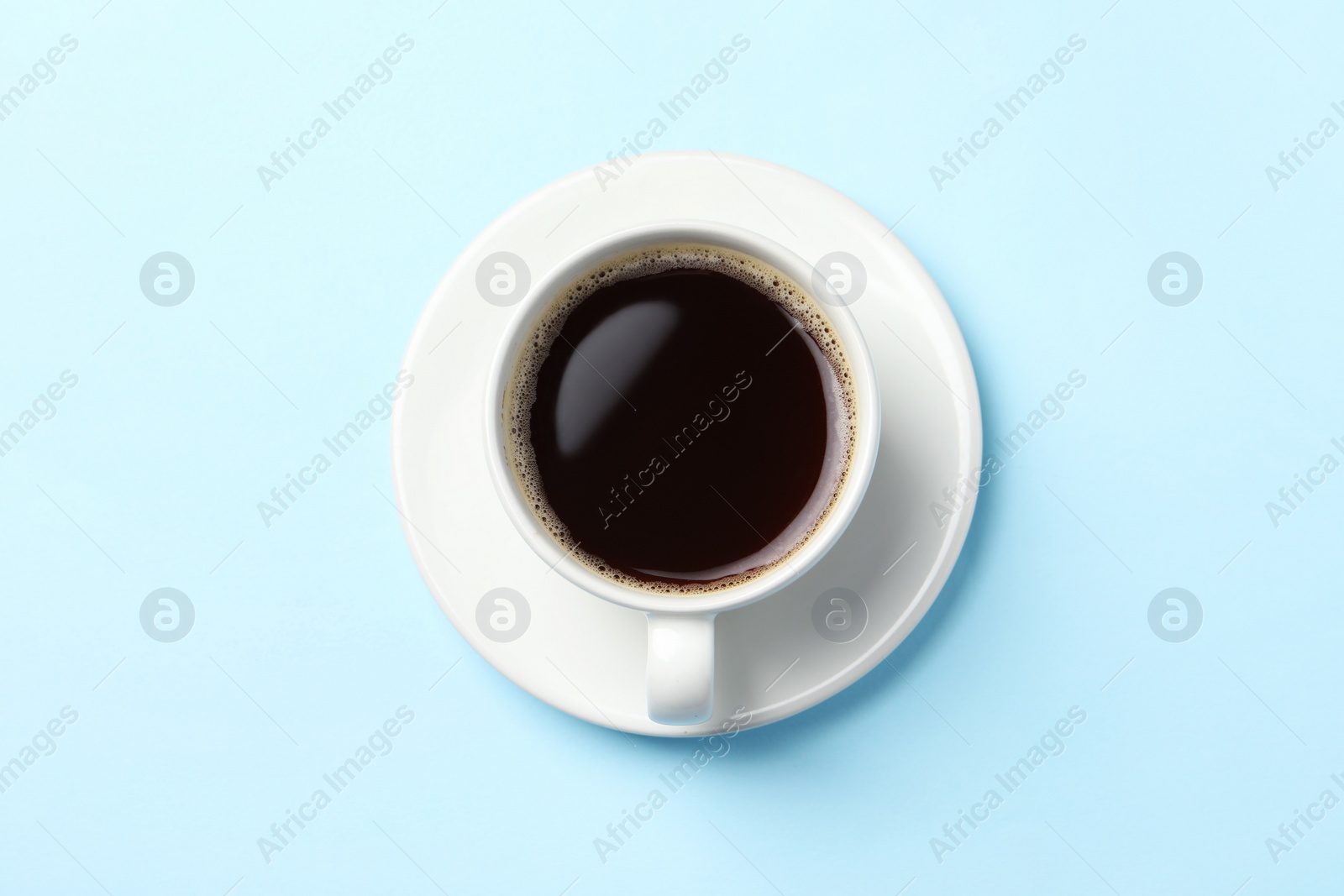 Photo of Cup of aromatic coffee on light blue background, top view