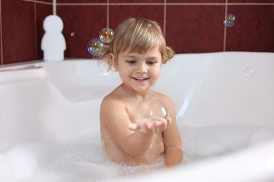 Photo of Happy girl having fun in bathtub at home