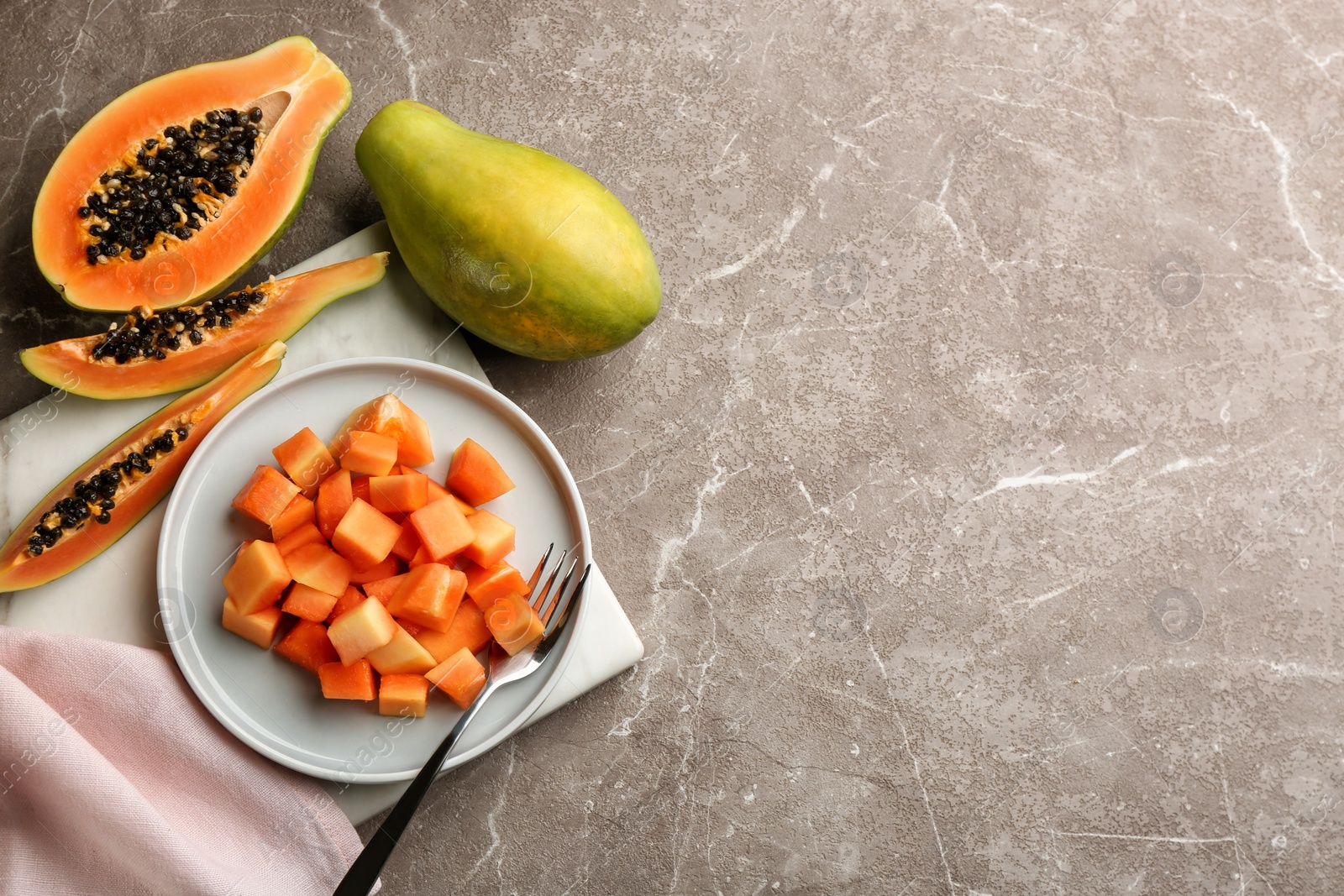 Photo of Fresh ripe papaya fruits on grey table, flat lay. Space for text