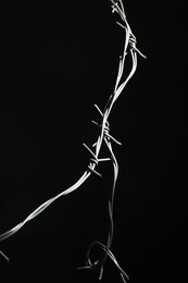 Photo of Shiny metal barbed wire on black background