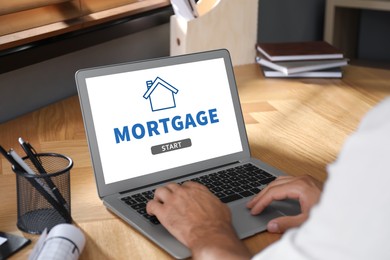 Image of Mortgage concept.  Man using modern laptop at table, closeup