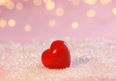 Photo of Red decorative heart on glitter against blurred lights