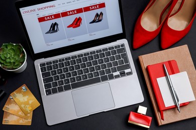 Online shopping. Composition with laptop on black background, above view