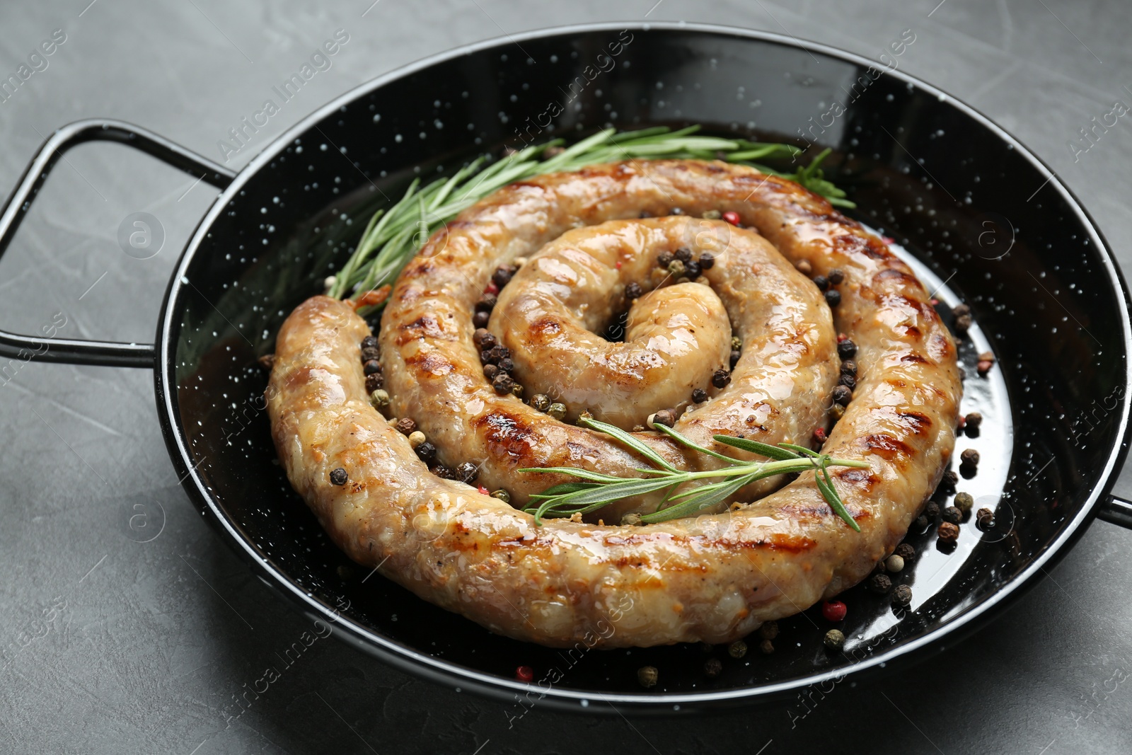 Photo of Tasty homemade sausages with spices on grey table, closeup