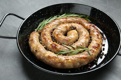 Photo of Tasty homemade sausages with spices on grey table, closeup