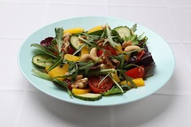 Photo of Tasty fresh vegetarian salad on white tiled table