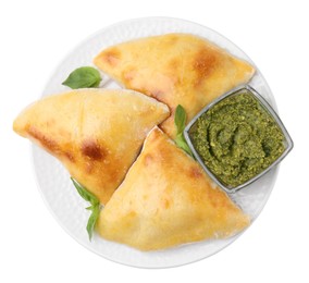 Delicious samosas with basil and pesto sauce isolated on white, top view