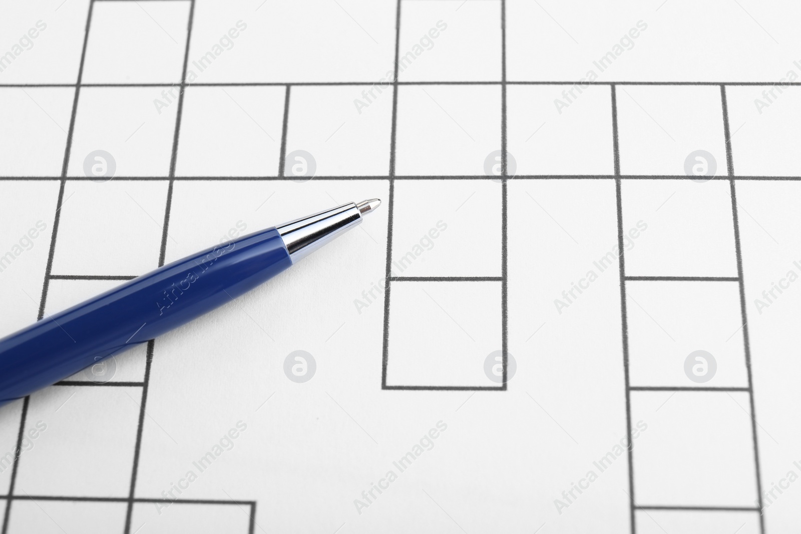 Photo of Pen on blank crossword, closeup. Space for text