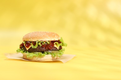 Photo of Burger with delicious patty on yellow background, space for text