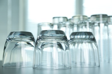 Photo of Empty glasses on grey table against blurred background, closeup