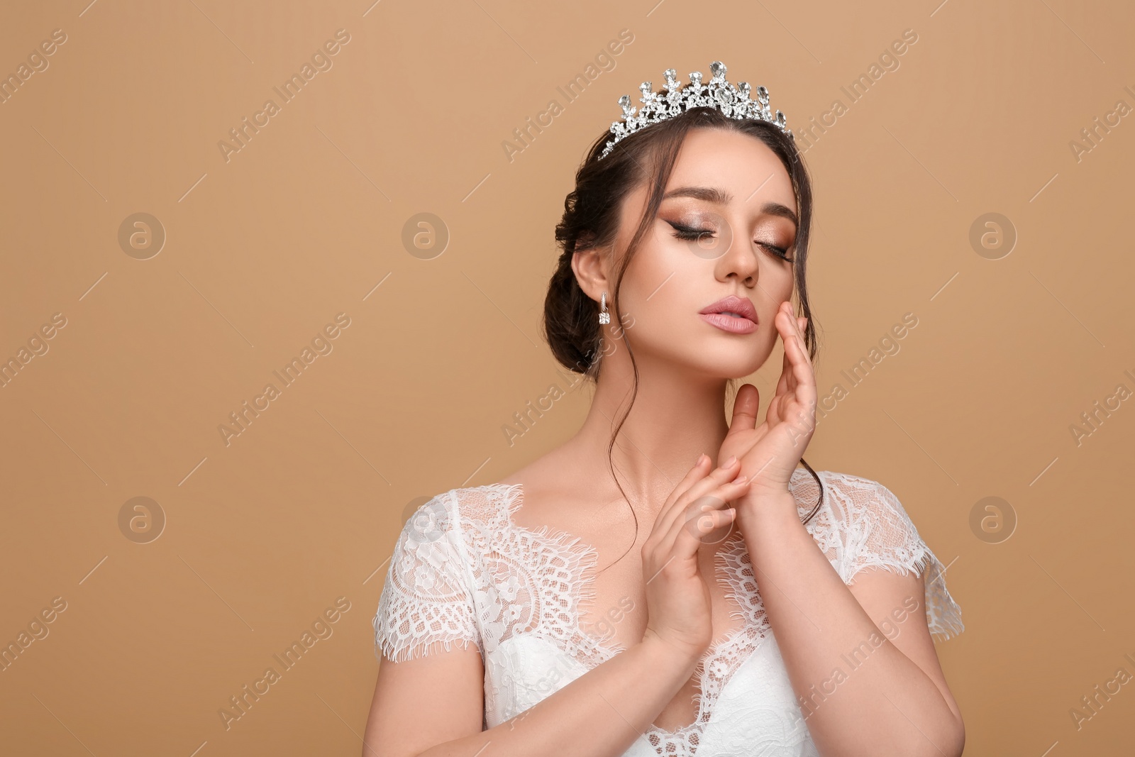 Photo of Beautiful young woman wearing luxurious tiara on beige background, space for text