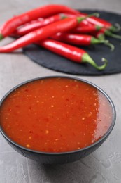 Photo of Spicy chili sauce in bowl on grey table