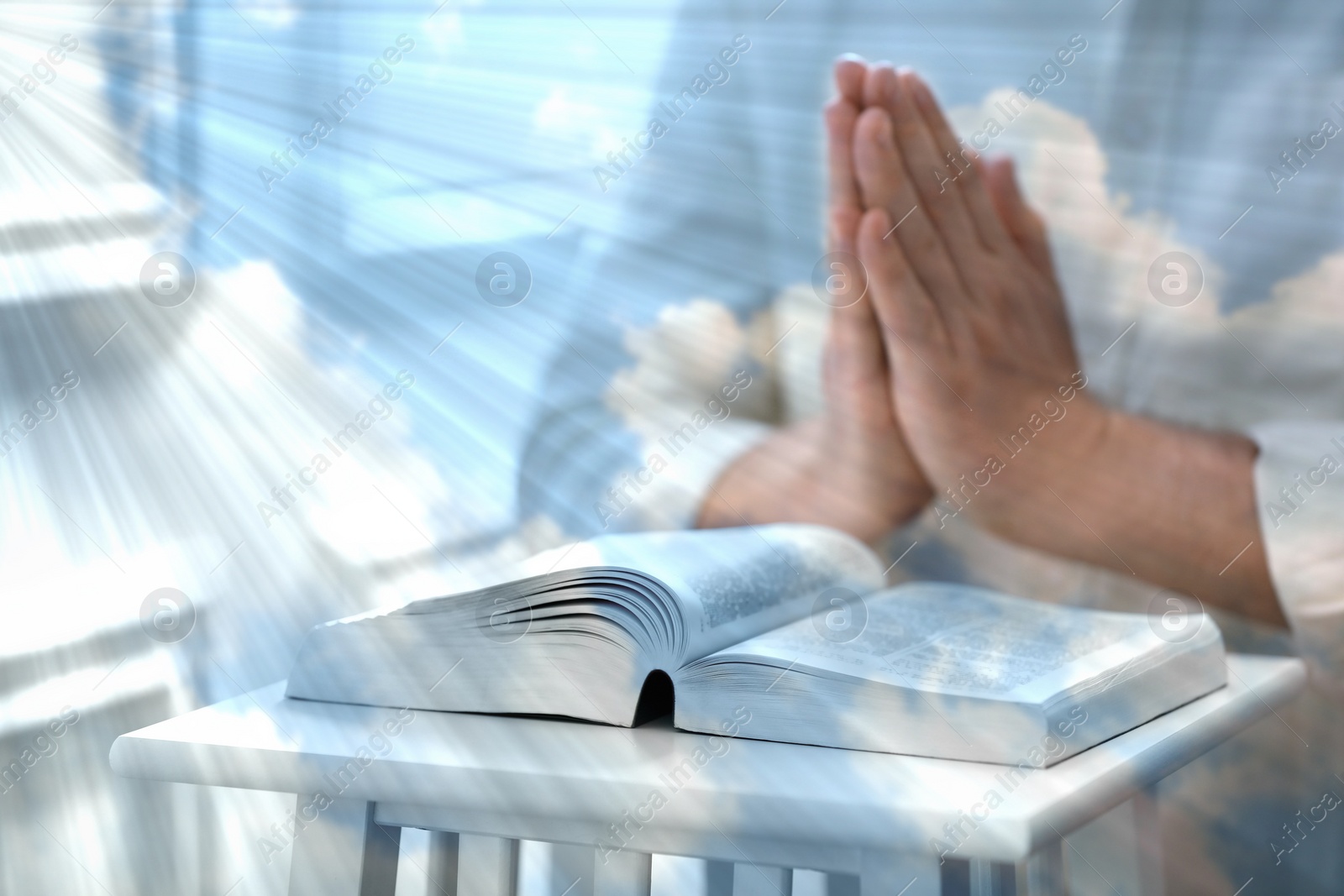 Image of Religion. Double exposure of sky and Christian man praying over Bible at table, closeup