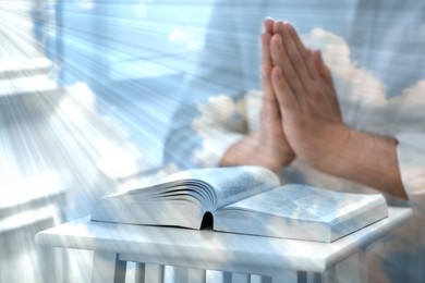 Image of Religion. Double exposure of sky and Christian man praying over Bible at table, closeup