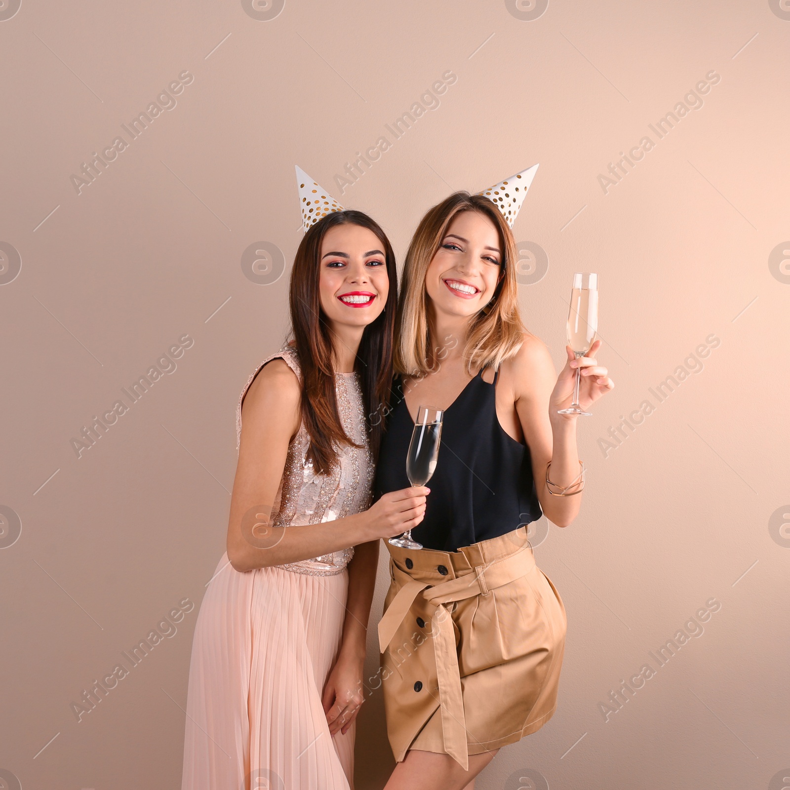 Photo of Portrait of happy friends with champagne in glasses on color background