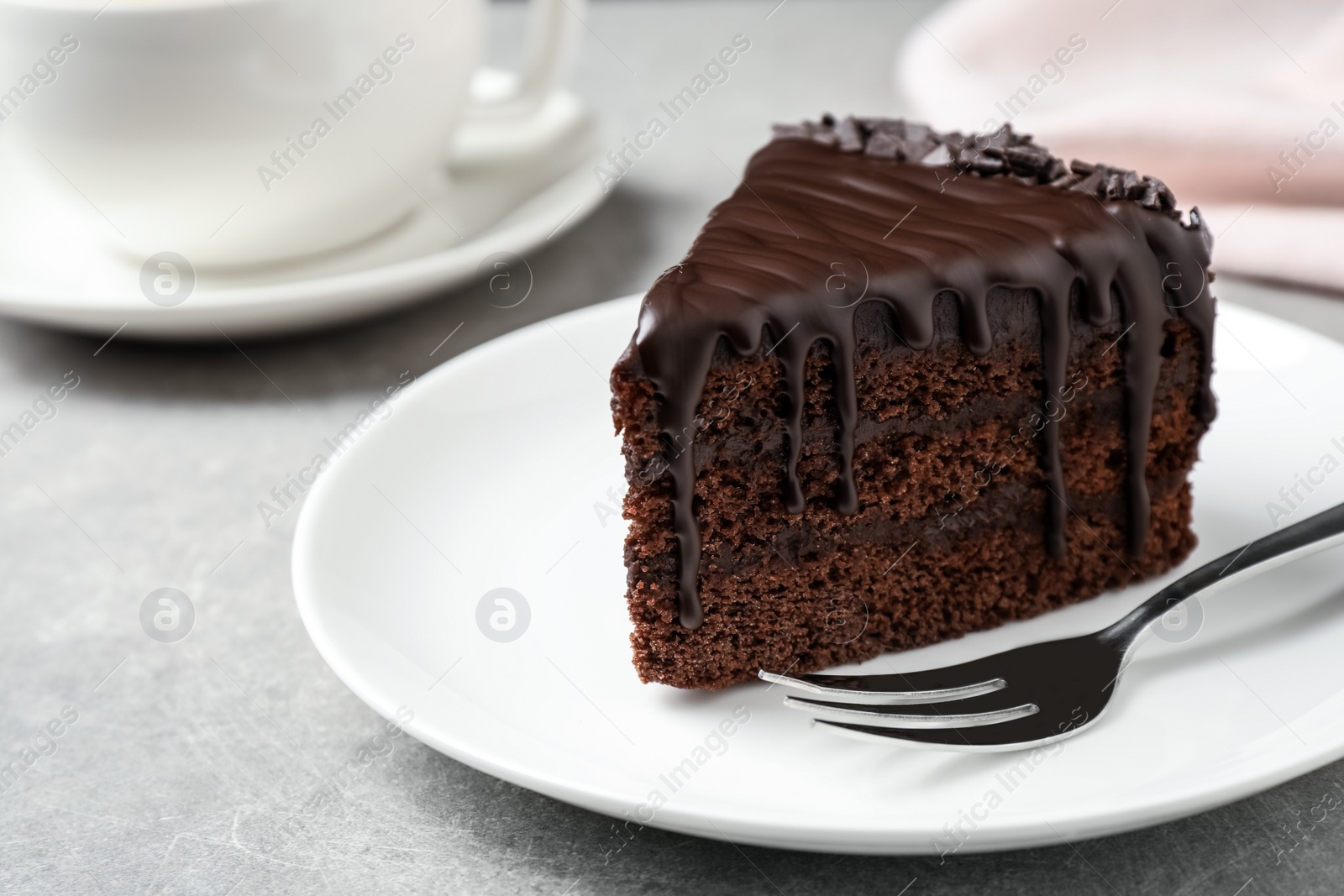 Photo of Delicious chocolate cake on light grey table, closeup