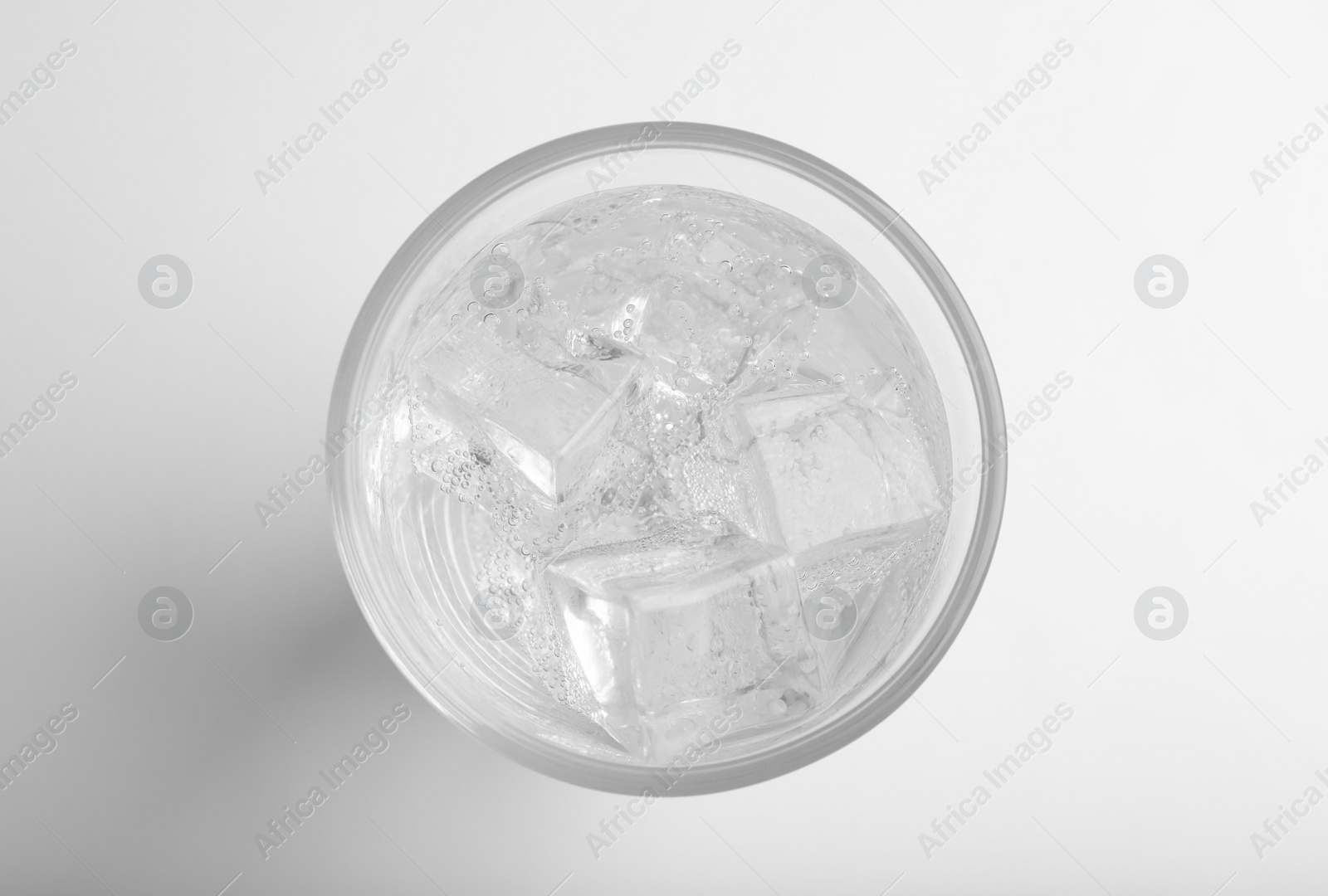 Photo of Glass of soda water with ice isolated on white, top view