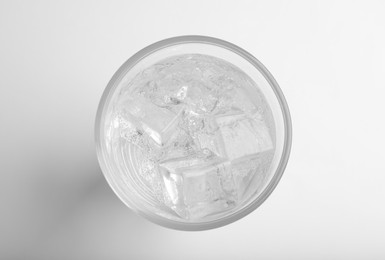 Photo of Glass of soda water with ice isolated on white, top view