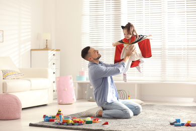 Photo of Father playing with his child at home