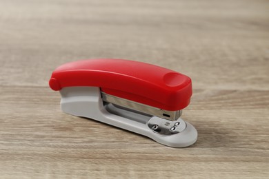 One bright stapler on wooden table, closeup