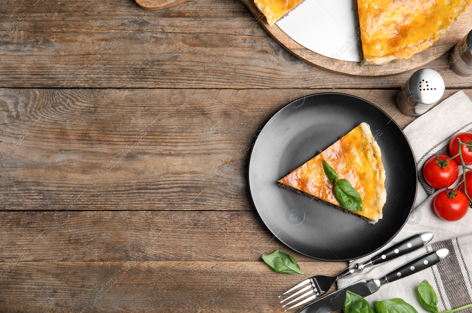 Photo of Piece of delicious pie with minced meat on wooden table, flat lay