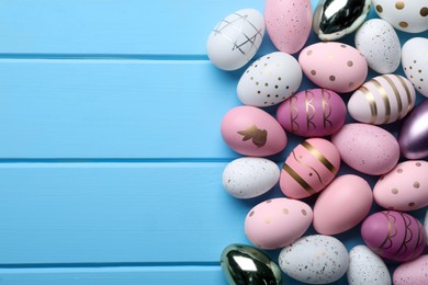 Photo of Many beautifully decorated Easter eggs on light blue background, flat lay. Space for text