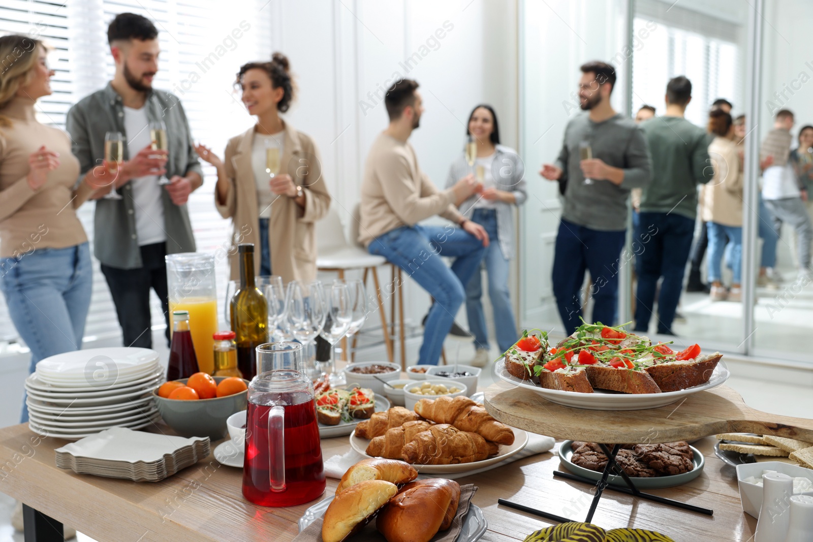 Photo of Brunch table setting with different delicious food	and blurred view of people on background