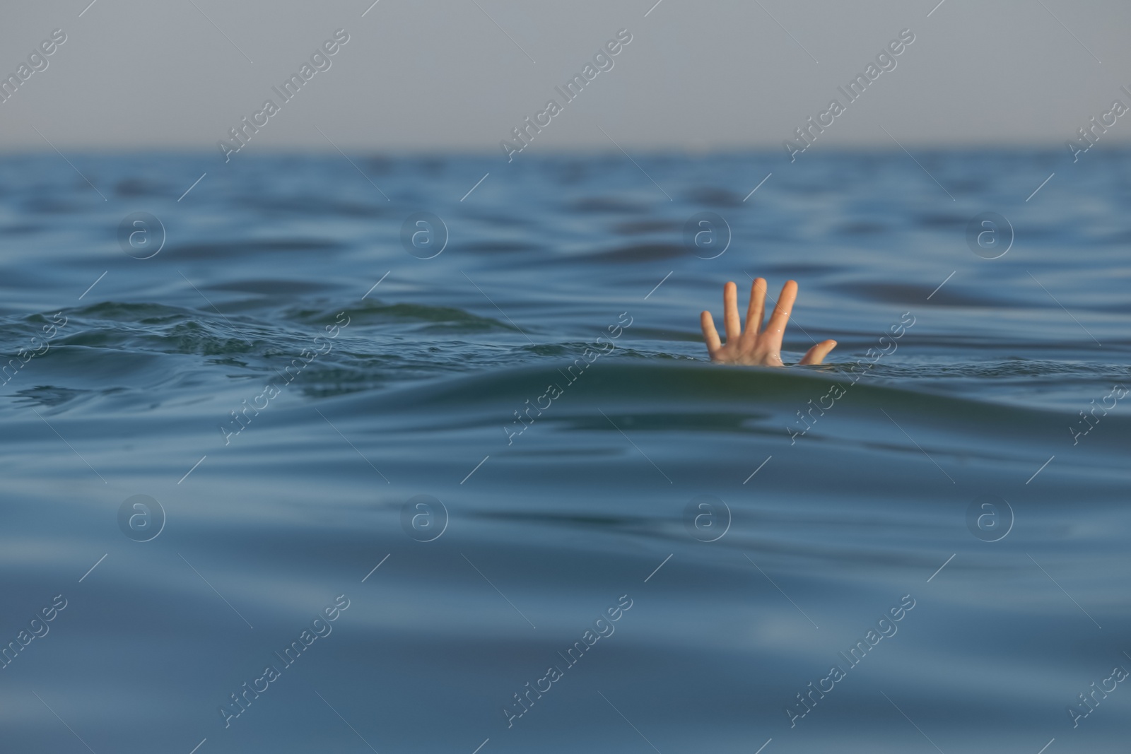 Photo of Drowning woman reaching for help in sea