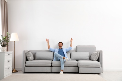 Photo of Young man relaxing on sofa at home