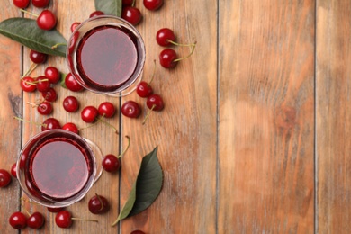 Photo of Delicious cherry wine with ripe juicy berries on wooden table, flat lay. Space for text