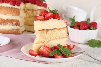 Piece of tasty cake with fresh strawberries and mint on white table