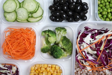 Set of plastic containers with fresh food on white wooden table, flat lay