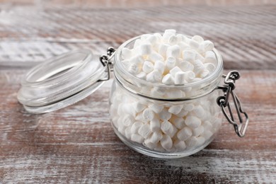 Photo of Glass jar with delicious marshmallows on wooden table