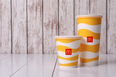 MYKOLAIV, UKRAINE - AUGUST 12, 2021: Cold McDonald's drinks on white wooden table. Space for text