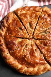 Photo of Cut delicious homemade pie on black table, top view