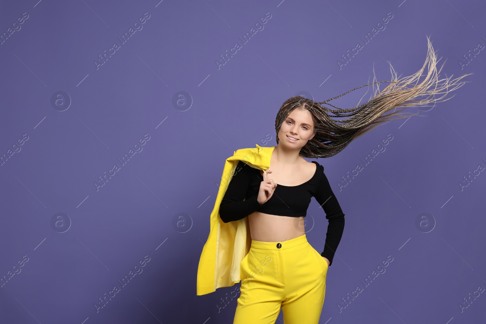 Photo of Beautiful woman with long african braids on purple background, space for text