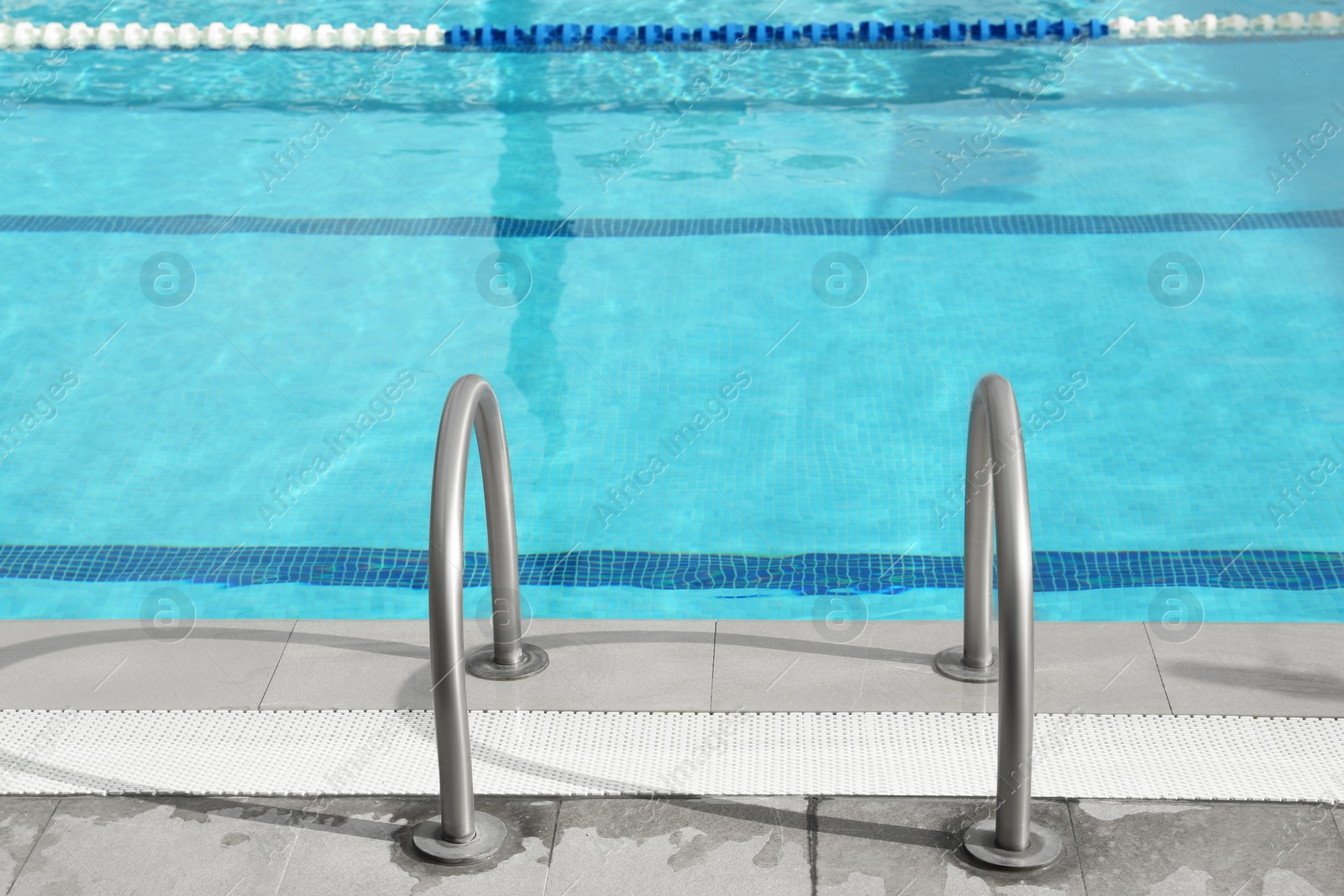 Photo of Ladder with handrails in outdoor swimming pool