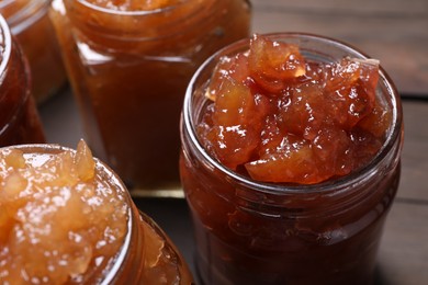 Photo of Delicious apple jam in jars on table, closeup