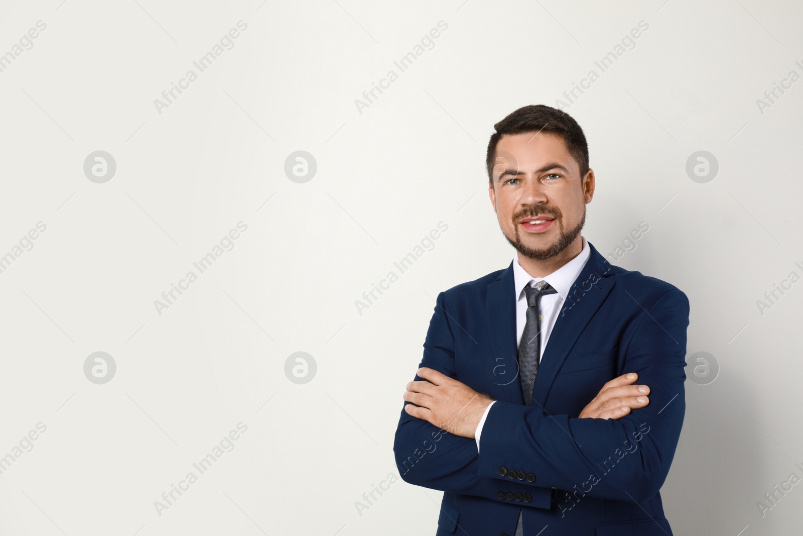 Photo of Portrait of handsome man in suit on light background. Space for text