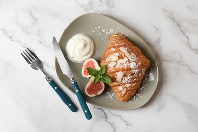 Photo of Delicious croissant with fig served on white marble table, top view