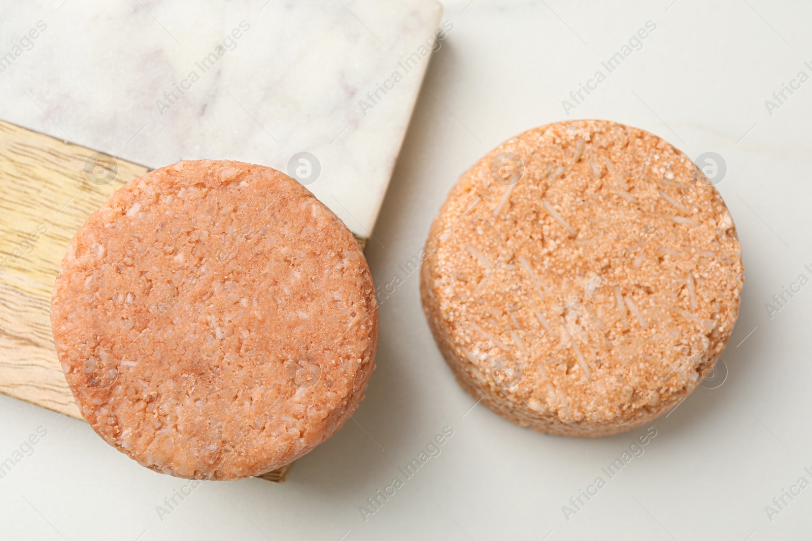 Photo of Natural solid shampoo bars on light table, flat lay