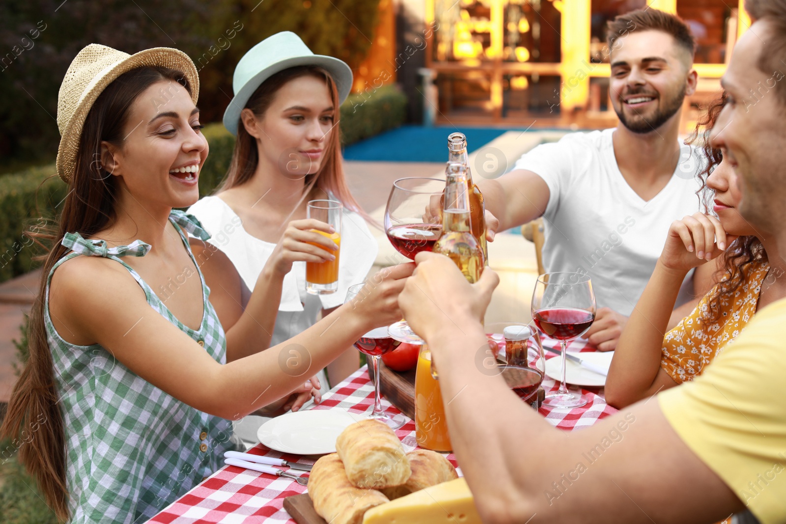 Photo of Happy friends with drinks having fun at barbecue party outdoors